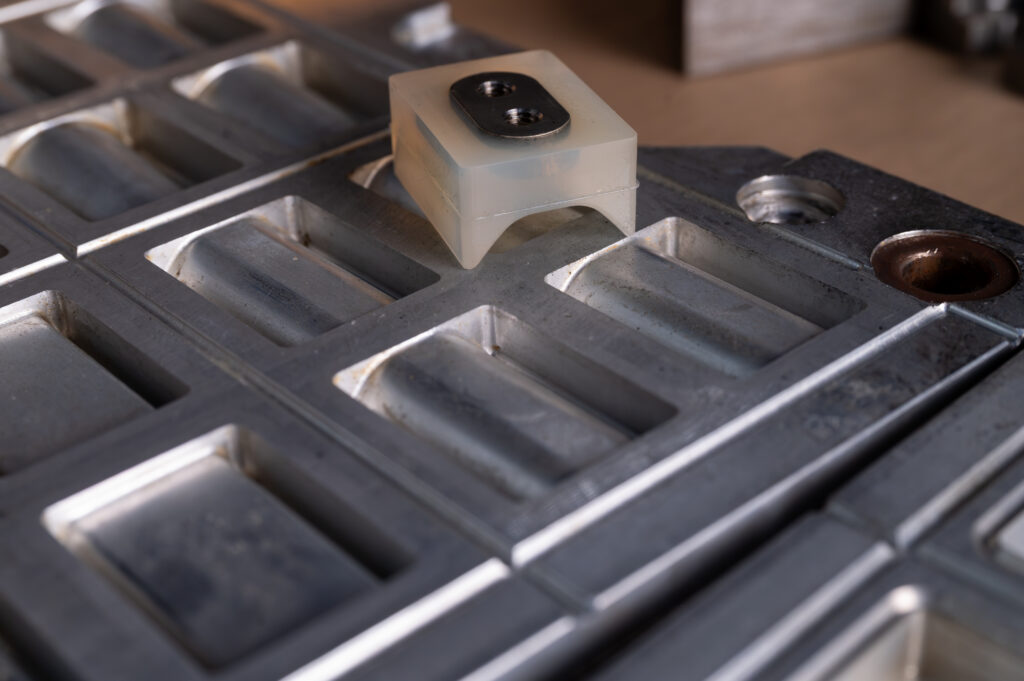 Darstellung der Kavitäten eines Werkzeuges inklusive eines fertigen Bauteils, das auf dem Werkzeug liegt.