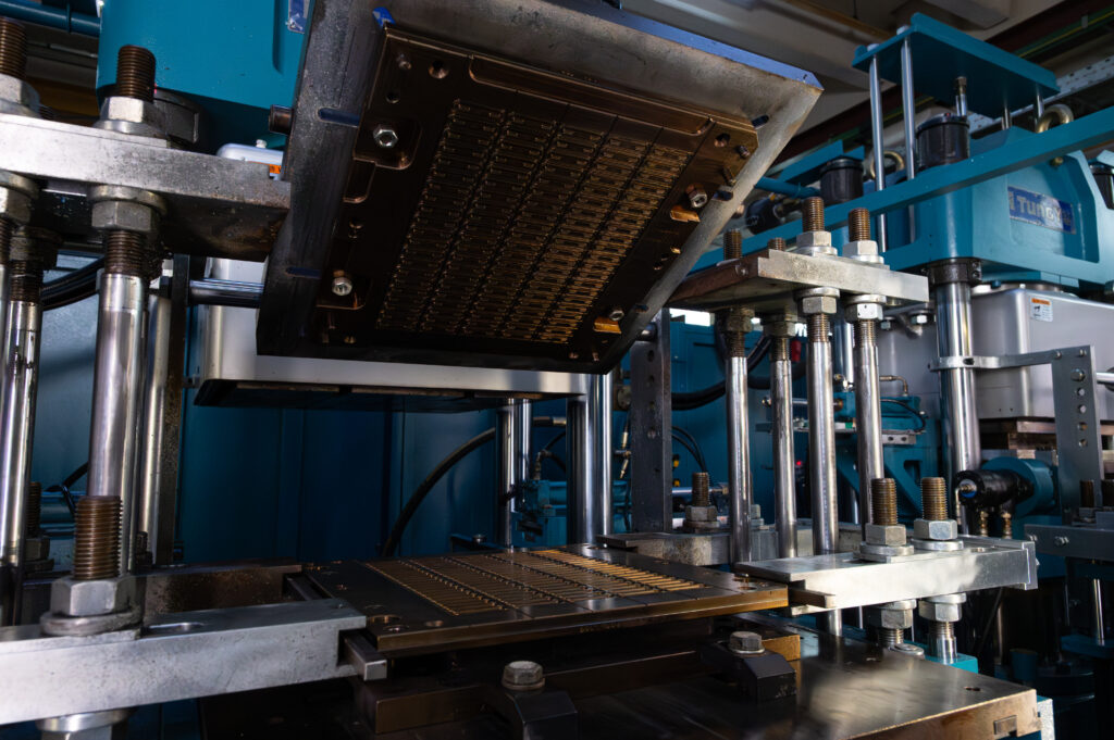 Opened press of a turquoise, black CM machine - GUME GmbH